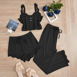 Flat lay of black rib-knit sleepwear set with intricate lace trim and white buttons
