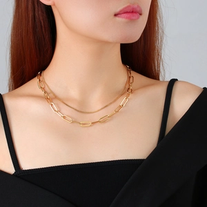 Detail of layered gold stainless steel necklace with flat paperclip and thin link chain