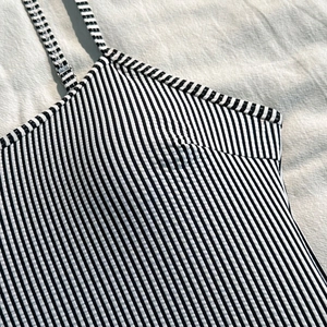 Macro detail of black and white striped swimsuit fabric with ribbed texture and fine stitching
