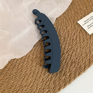 Vue détaillée de la pince banane en acrylique bleu mat montrant sa structure à dents multiples