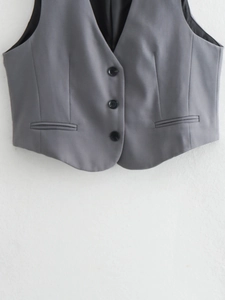 Détail du gilet de costume gris moyen avec trois boutons noirs et poches passepoilées