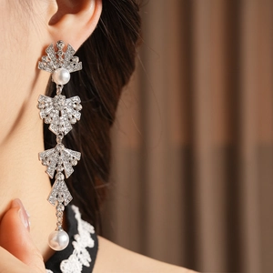 Close-up of model wearing silver tassel earrings with sparkling rhinestones and pearls