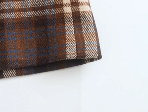 Close-up of the vintage plaid wool fabric texture in brown, blue and beige tones