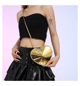 Detail einer roten herzförmigen Crossbody-Tasche mit glänzender Oberfläche und Goldkette