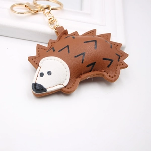 Detail of cute brown PU leather hedgehog keychain with gold-tone metal hardware