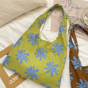 Detailed fabric texture of canvas tote bags with blue floral patterns in green and brown