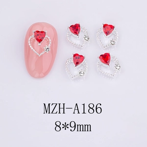 Detail view of 8x9mm heart-shaped red nail gems with silver metal frame and small diamonds