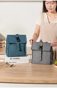 Detail view of large insulated lunch bags with buckle closure in teal and grey colors