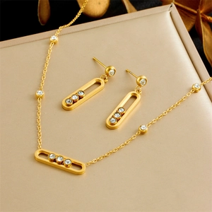 Luxurious gold U-shaped earring and necklace set with sparkling triple diamond pendants