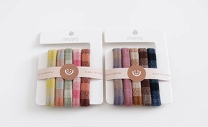 Detail of high-elastic waffle texture hair ties in colorful plaid patterns on card boards