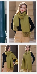 Detail shot of a soft mustard green scarf with long tassels and thick texture