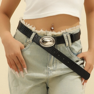 Women's black crocodile pattern belt with silver oval buckle on blue jeans