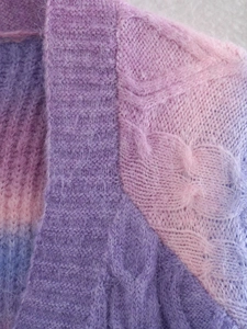 Detailed macro shot of pink and purple gradient cable knit mohair cardigan texture