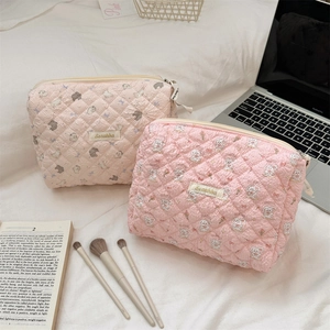 Quilted cotton cosmetic bags with cute rabbit patterns on a cozy white bedroom setting