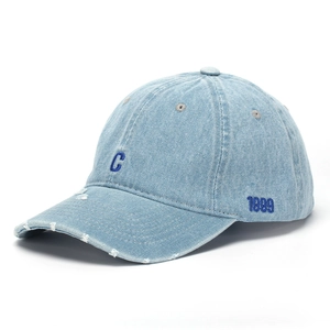 Close-up of distressed denim baseball cap with navy letter C embroidery and retro frayed edge