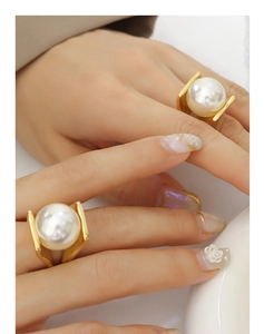 Detail of elegant 18k gold-plated rings with large white pearls on hand for women