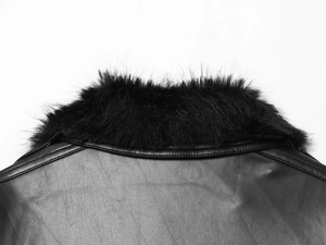 Gros plan sur la texture du cuir noir et le col en fausse fourrure moelleux de la veste