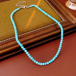 Detail of turquoise beaded necklace featuring silver lobster clasp and extension chain