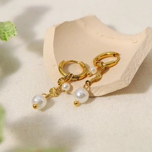 French luxury 18K gold earrings with round pearl pendants and fan texture on ceramic