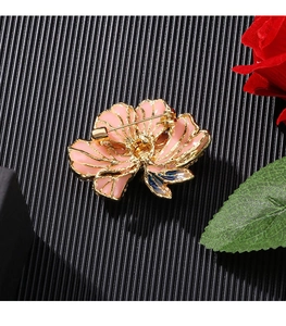 Detail of pink enamel peony brooch with gold edges and blue gradient leaf detail