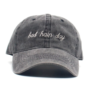 Detail of embroidered 'bad hair day' text on black washed cotton baseball cap
