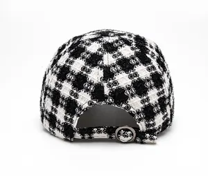 Rear view of a houndstooth tweed baseball cap showing the adjustable metal buckle closure