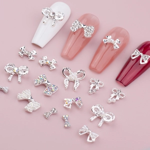 Gros plan de nœuds argentés pour ongles avec perles et strass pour décoration manucure