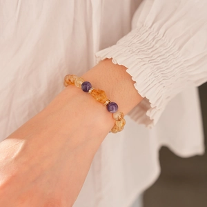 Close-up of yellow and purple crystal beaded bracelet on a woman wrist showing bead texture