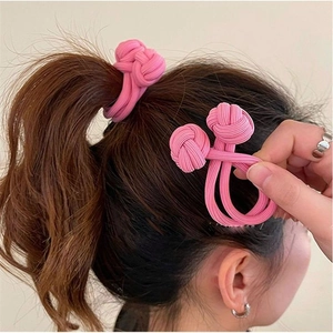 Close-up of pink twisted high elasticity hair tie shown on ponytail and in hand