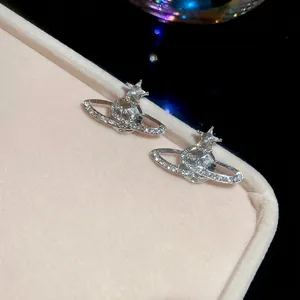 Elegant silver Saturn planet earrings with sparkling crystals on pink velvet box