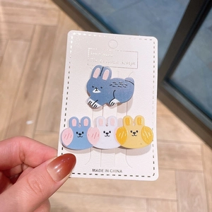 Detail of four cute acrylic cartoon bunny hair clips in blue, white and yellow colors