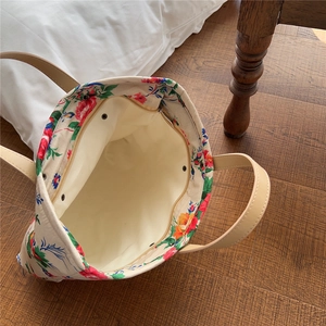 Detail of floral tote bag interior showing metal zipper pocket and magnetic buckle