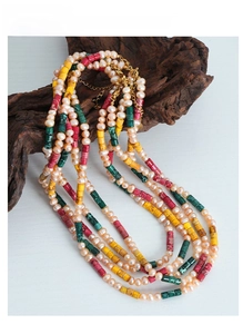 Detail of multilayer necklace with freshwater pearls and colorful stone beads on driftwood