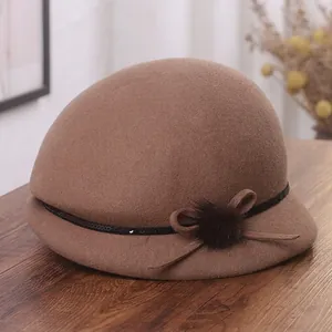 Chapeau cloche en laine marron avec nœud en velours et pompon sur bois