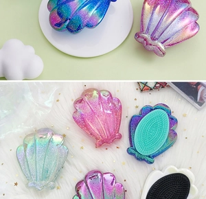 Macro shot of shell-shaped detangling hairbrushes with glitter electroplated finish