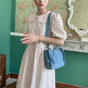 Retro blue washed denim tote bag with shoulder strap shown on a floral dress model