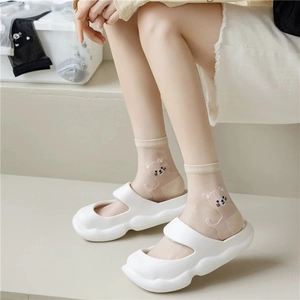 Detail of beige sheer mesh socks with cartoon bear print and white platform sandals