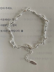 Close-up of S925 sterling silver bow bracelet with adjustable lobster clasp and logo tag