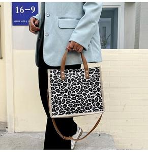 Detail of leopard print canvas tote bag featuring brown handles and large capacity design