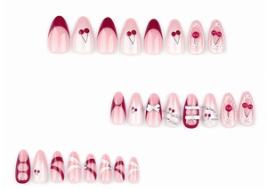 Dettaglio unghie finte rosse e rosa con decorazioni ciliegia, fiocchi e pizzo