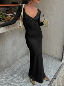 Elegante abito da sera longuette nero a maniche lunghe con scollo a V in un caffè