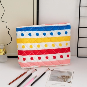 Close-up of quilted cosmetic bag featuring multi-colored stripes and white polka dots