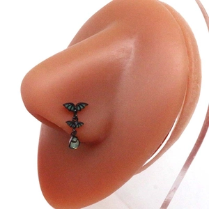 Gothic black bat septum ring with dark green gemstone accents on nose model