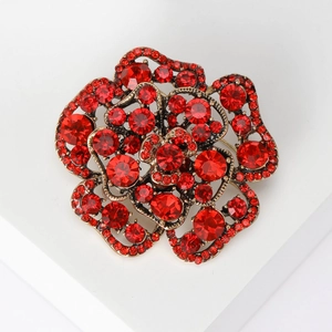 Macro shot of vintage style rose brooch with sparkling red rhinestones on bronze base