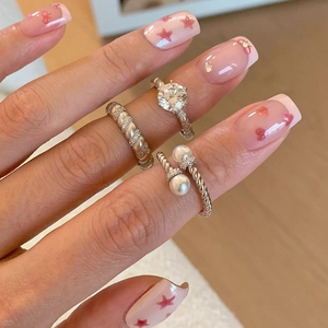 Elegant silver-toned twisted rings with crystals and pearls worn on hand