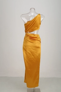 Détail d'une robe en satin jaune à une épaule avec découpe à la taille et drapé élégant