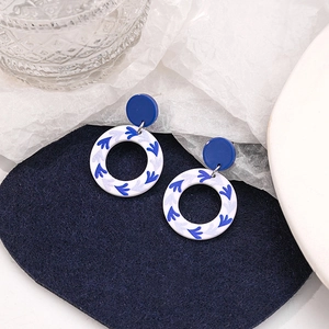 Detail of blue and white porcelain style drop earrings on navy blue felt background