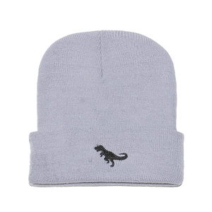 Close-up of baby blue knit beanie featuring detailed black dinosaur embroidery on cuff