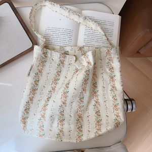 Detailed close-up of a floral cotton shoulder bag with simple wish brand tag detail