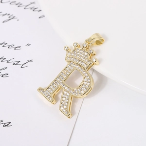 Macro shot of gold-plated crown letter R pendant with sparkling micro-pave zircons